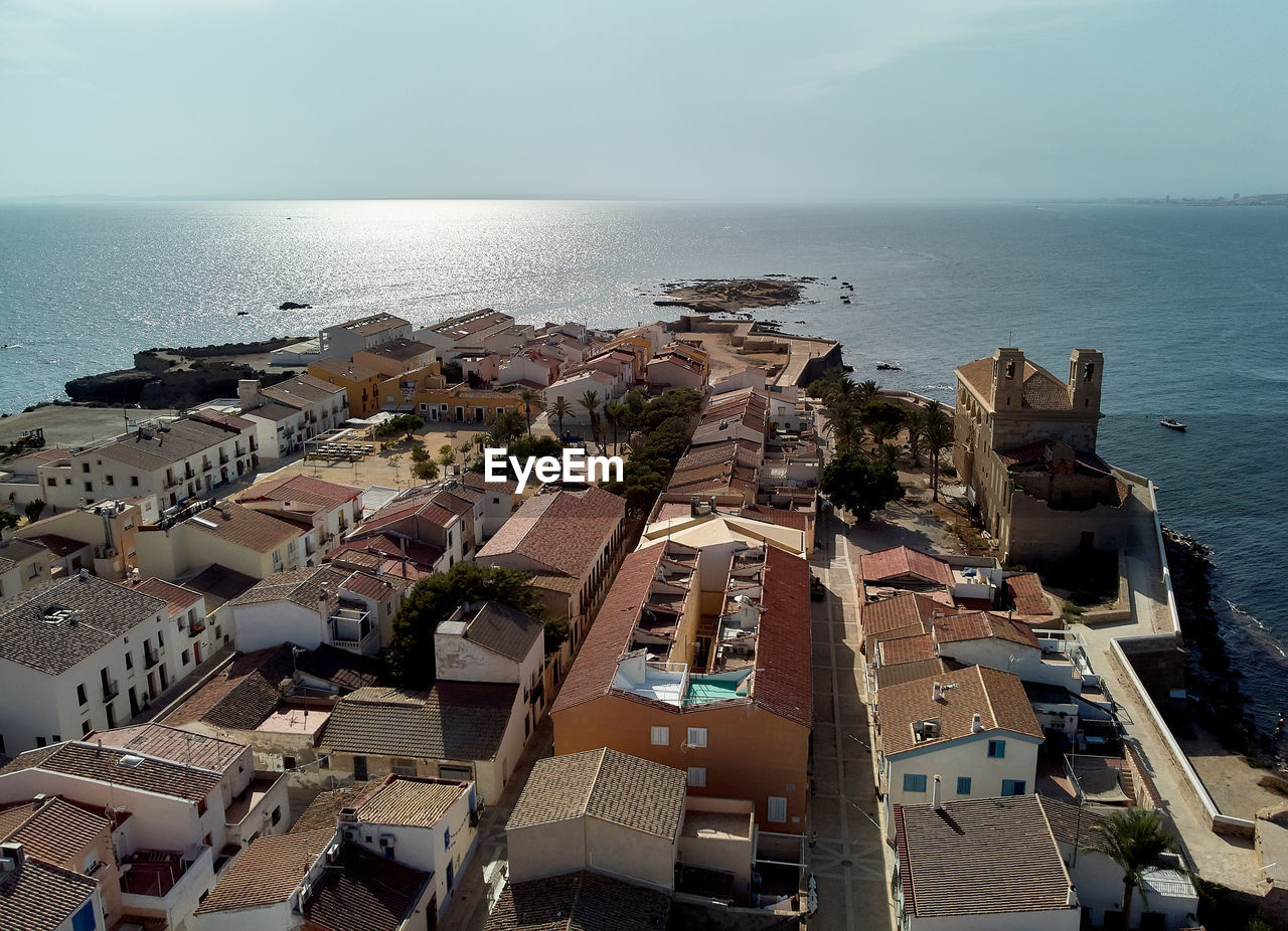 HIGH ANGLE VIEW OF TOWNSCAPE BY SEA