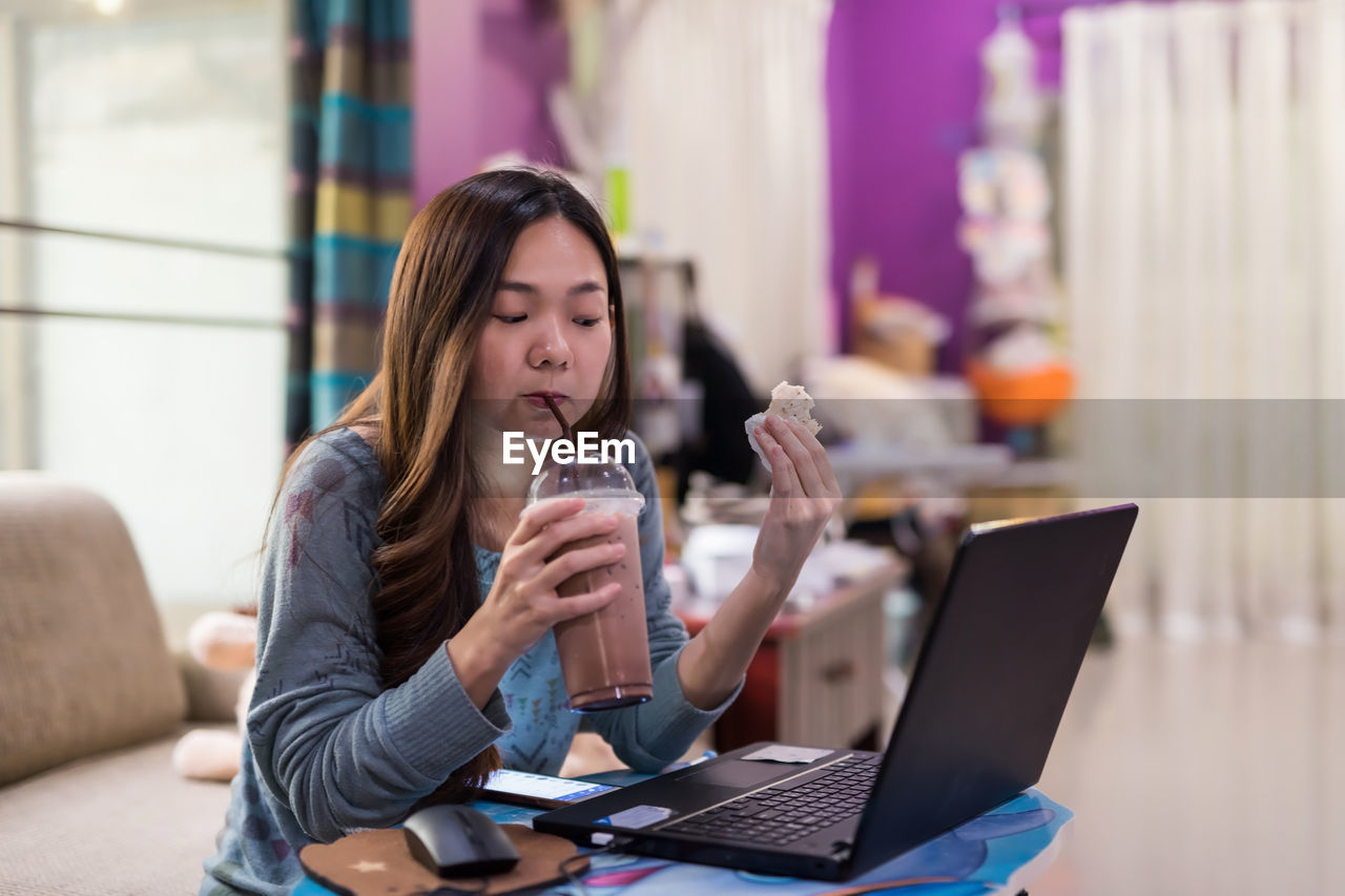 Young woman using laptop at home