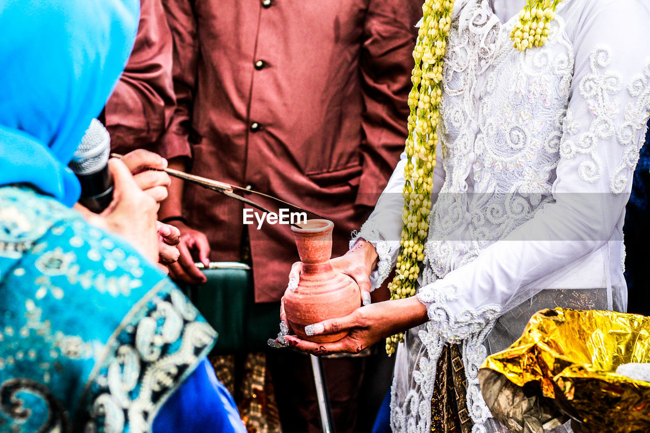 Midsection of bride and bridegroom during wedding ceremony