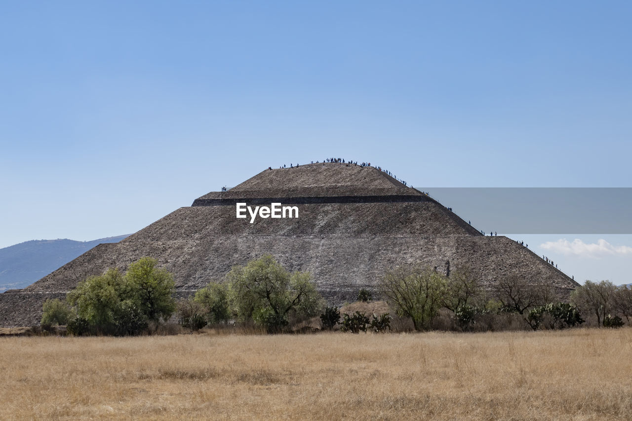 BUILT STRUCTURE ON FIELD AGAINST SKY