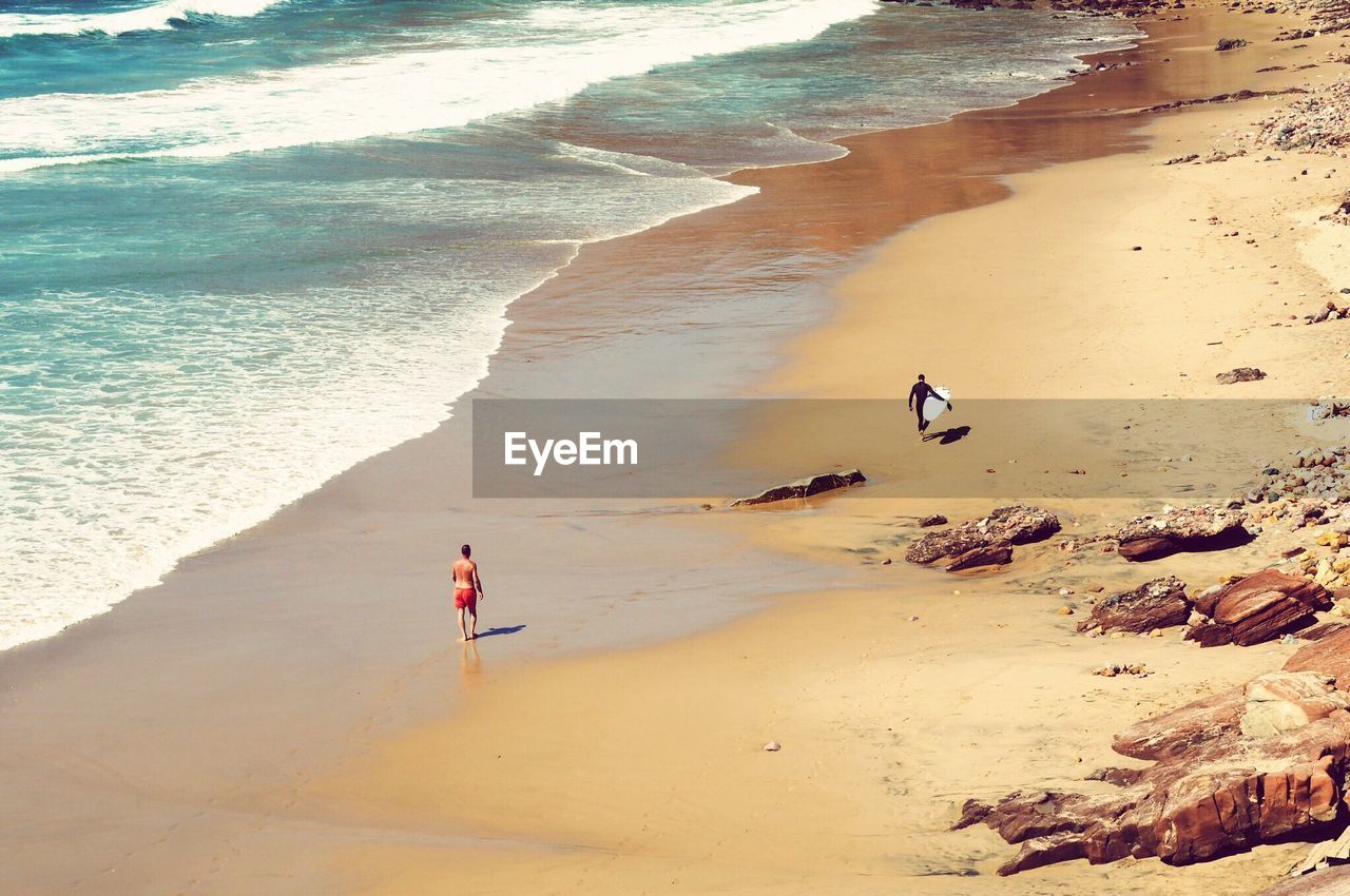 People standing on beach by sea