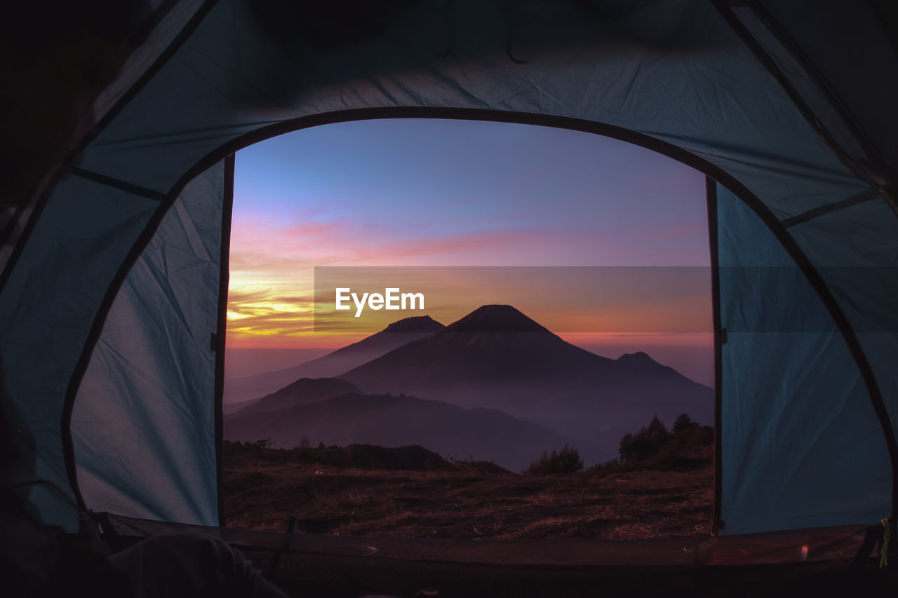 Scenic view of tent on mountain against sky during sunset