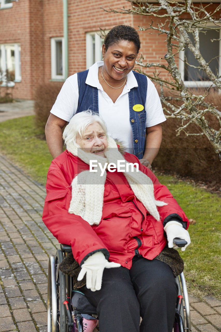 Nurse on walk with senior woman on wheelchair