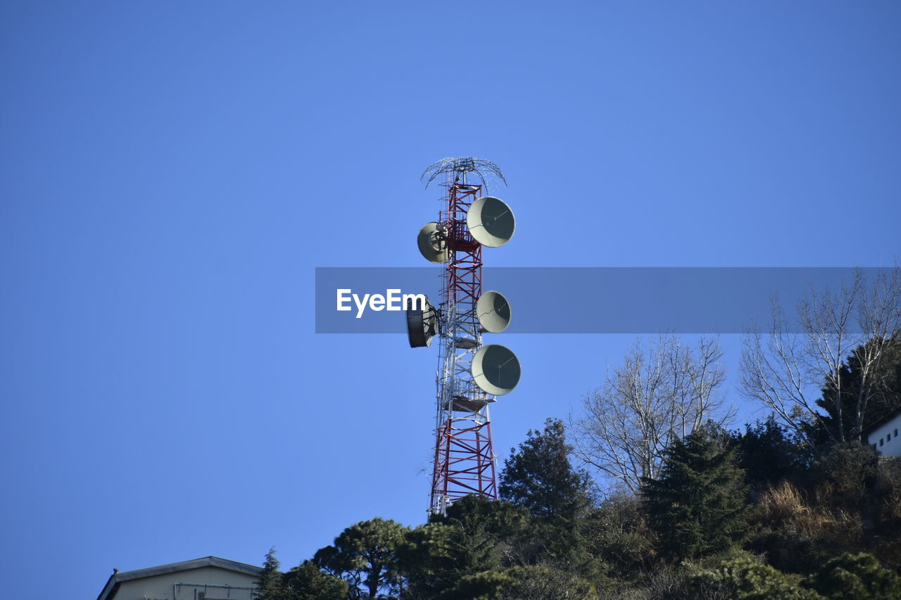 sky, tree, blue, clear sky, low angle view, nature, plant, lighting, communication, street light, no people, light fixture, day, architecture, technology, outdoors, sunny, copy space, built structure, broadcasting