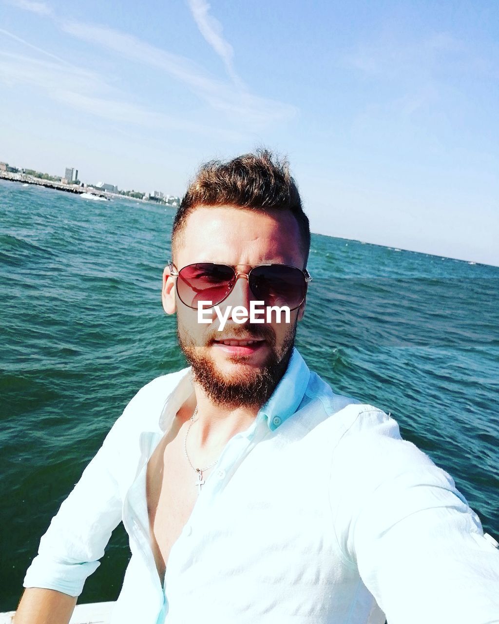 Portrait of young man against sea