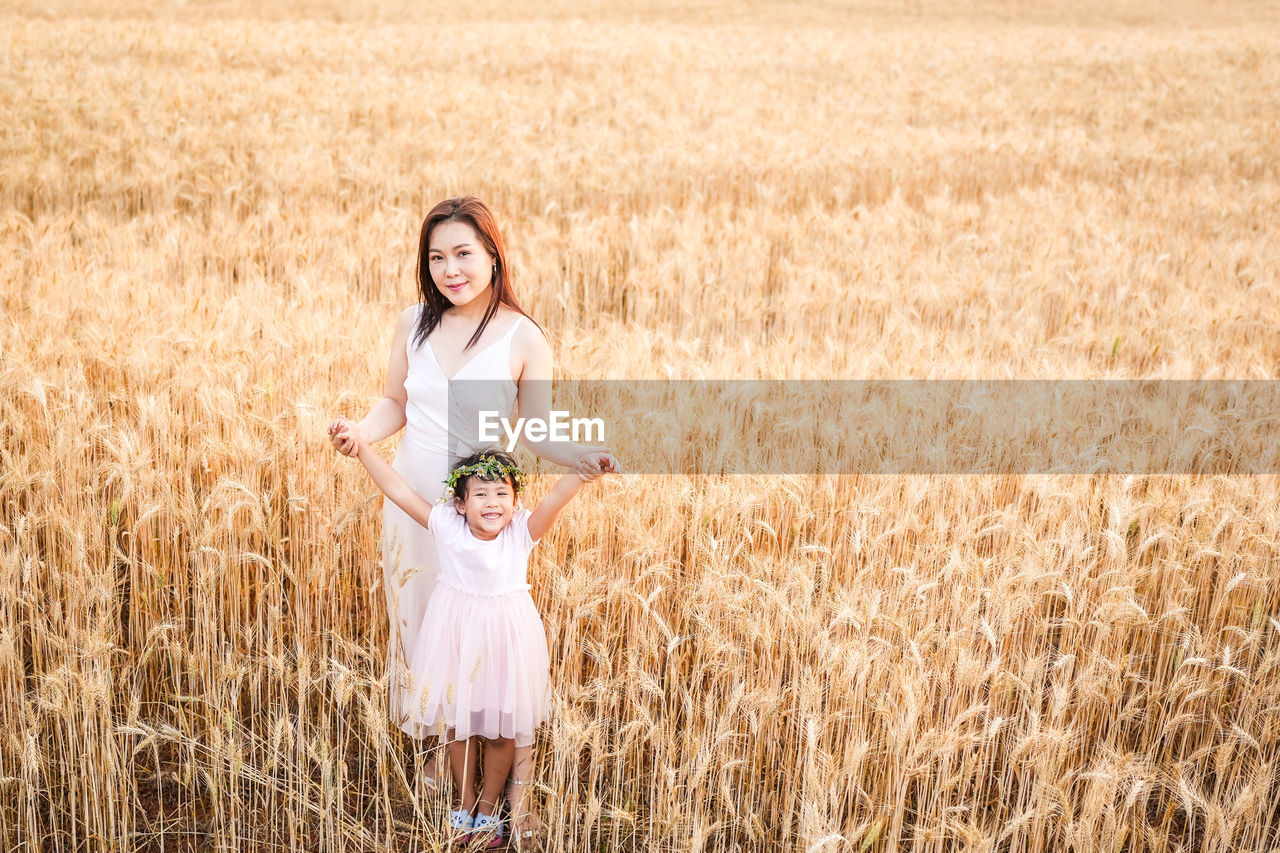 portrait of young woman standing on grassy field