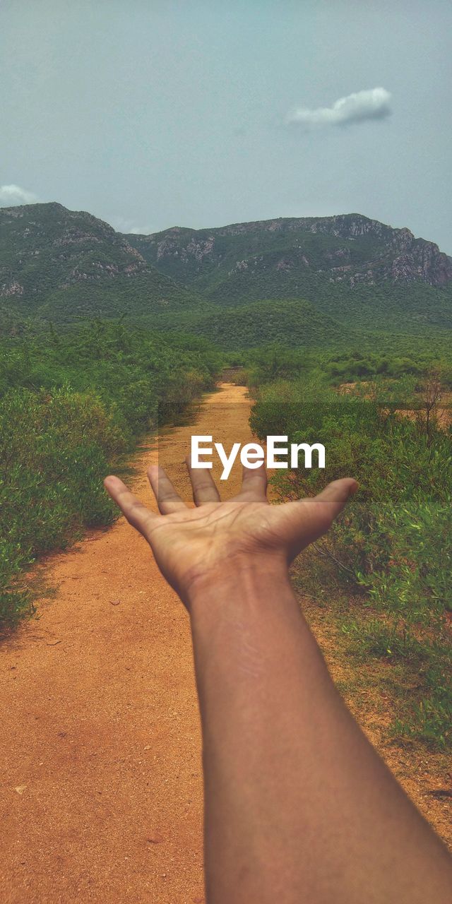 HUMAN HAND ON MOUNTAIN