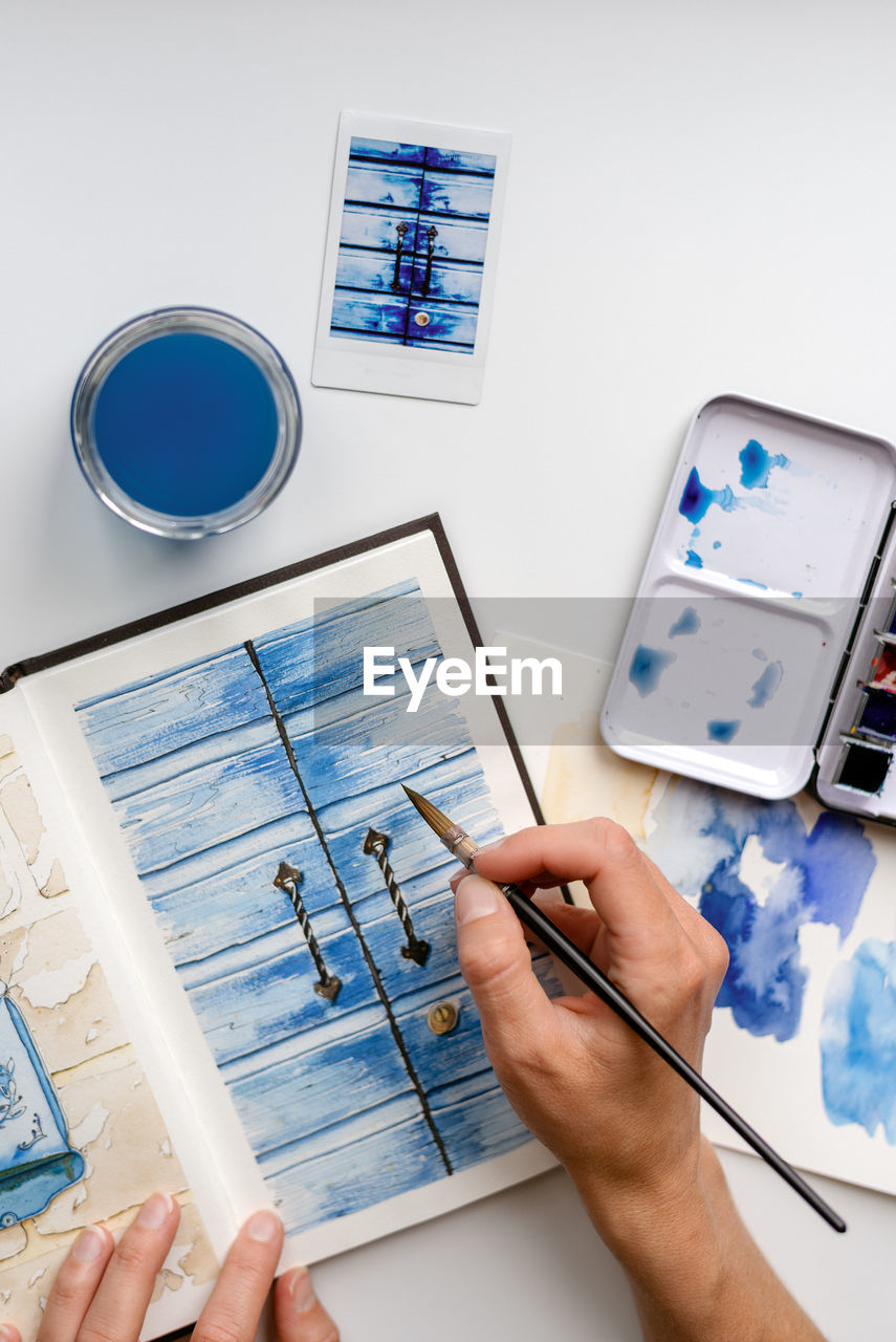 The artist adds the final details on the watercolor sketch.
