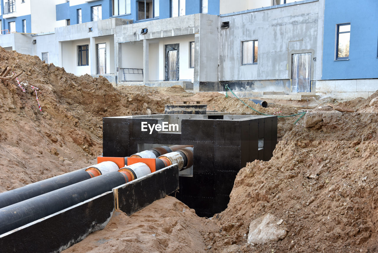 Laying heating pipes in a trench at construction site. install underground storm systems of water 