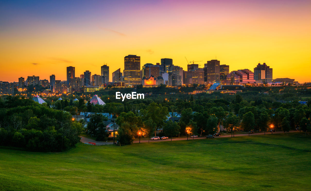 high angle view of buildings in city at sunset