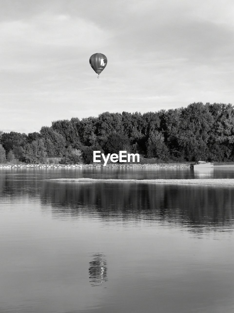 VIEW OF HOT AIR BALLOON IN LAKE AGAINST SKY