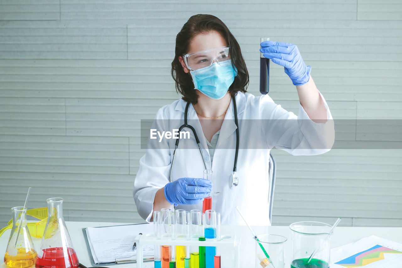 Female scientist examining chemical at laboratory