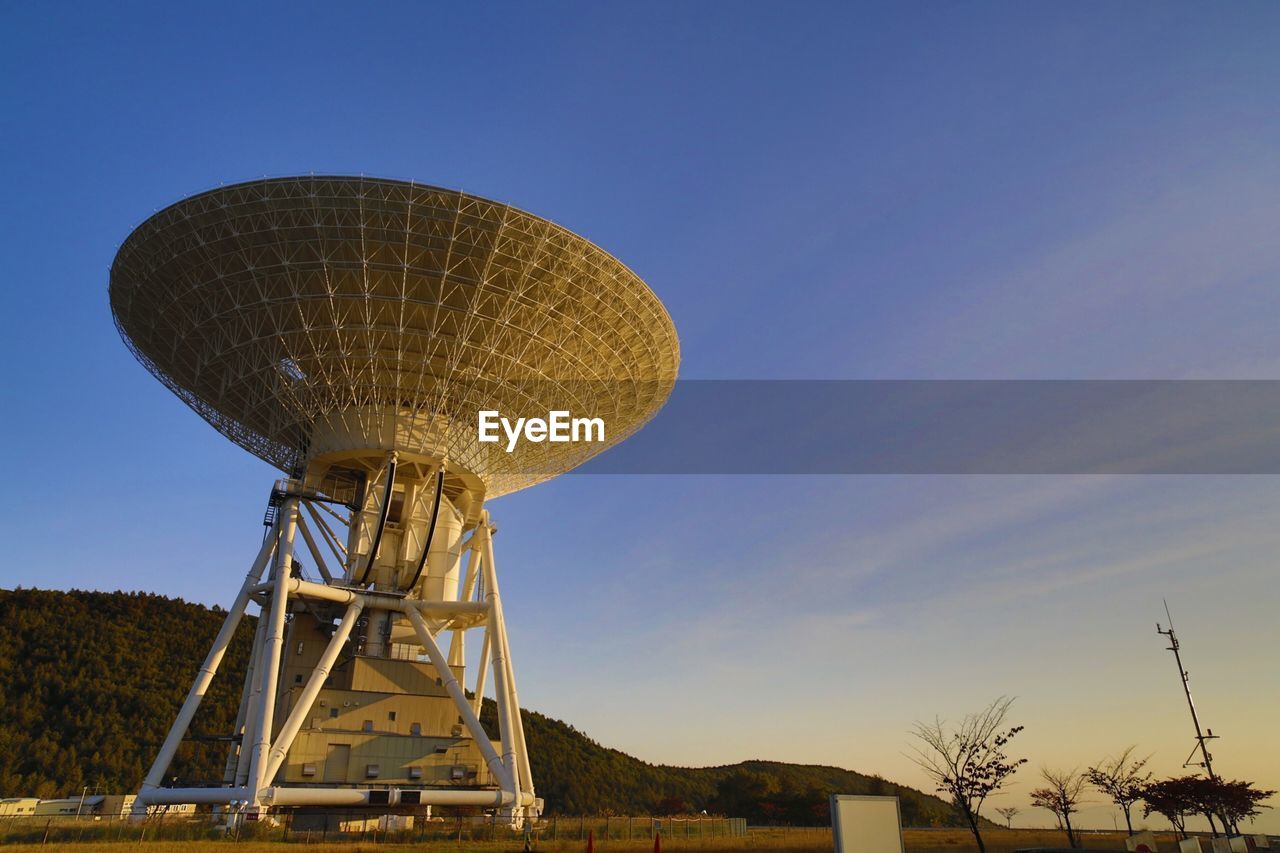 Low angle view of metallic satellite dish against sky