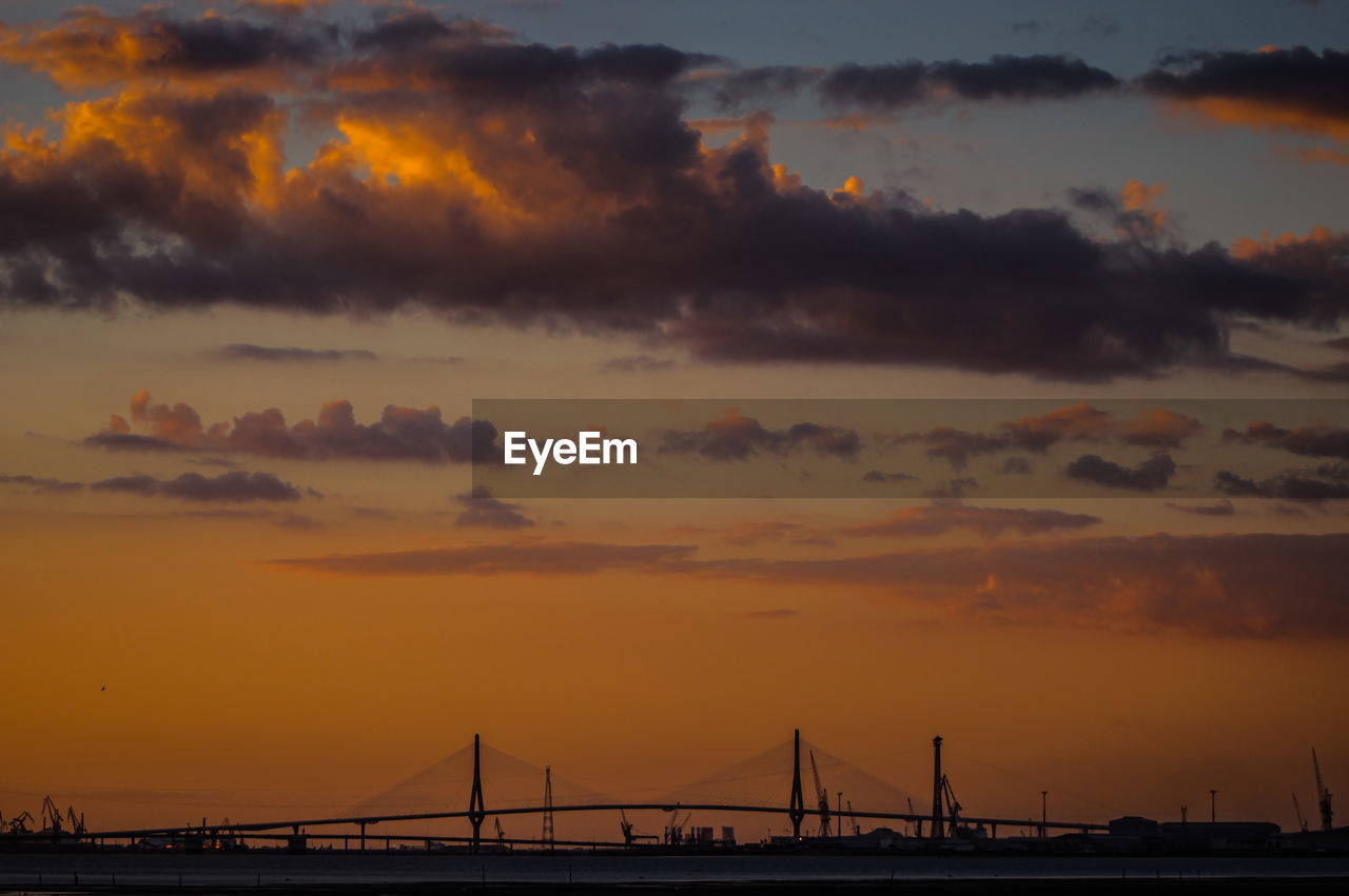 Silhouette bridge against sky during sunset