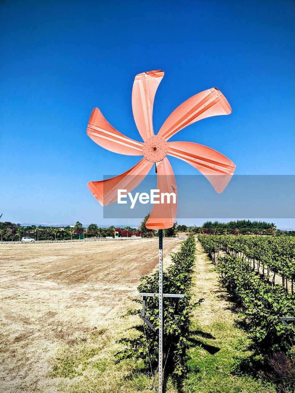 Traditional windmill on field against clear blue sky