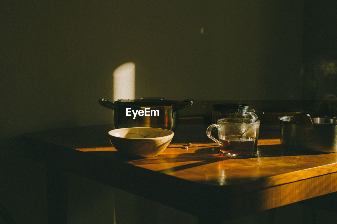 Breakfast with tea cups on the wooden table, early morning with hot food and drink.