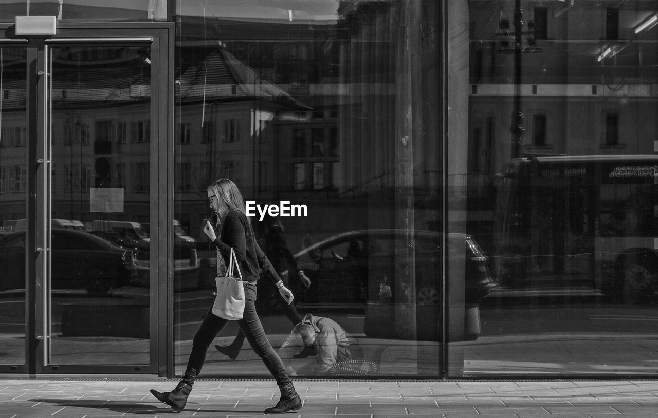 WOMAN WITH UMBRELLA WALKING ON STREET