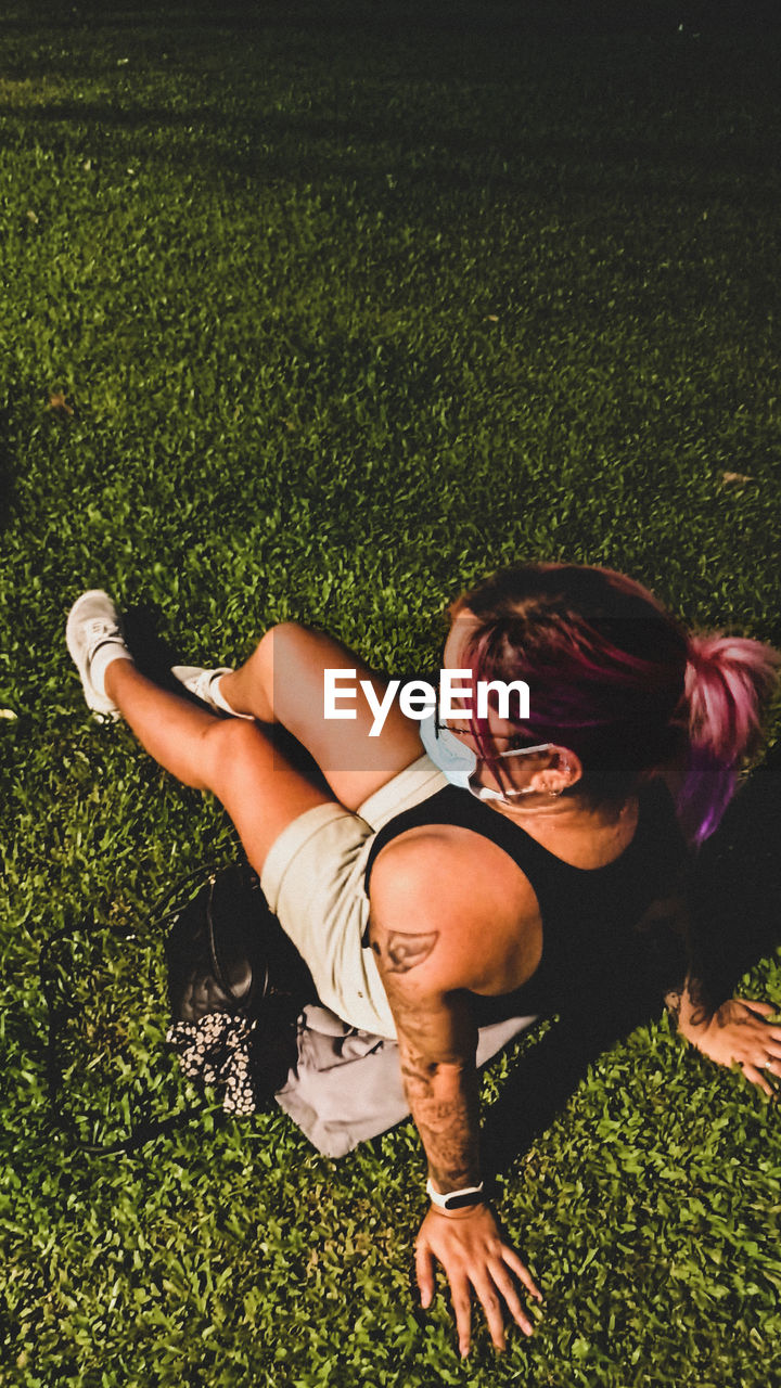 Full length of woman lying on grassy field