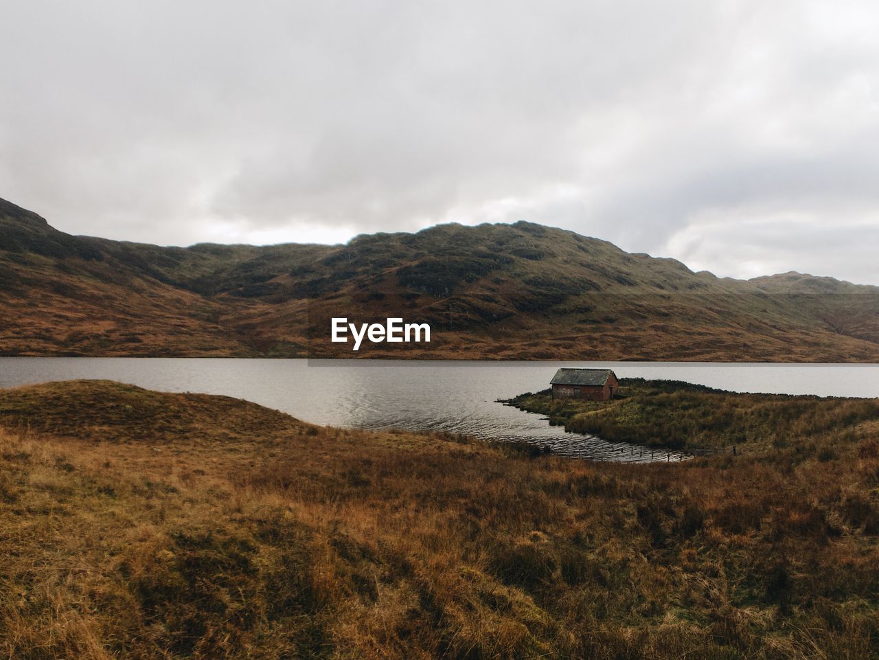 SCENIC VIEW OF LAKE BY MOUNTAIN AGAINST SKY