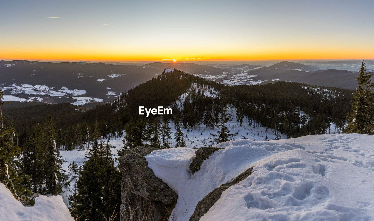 Scenic view of snowcapped mountains against sky during sunset