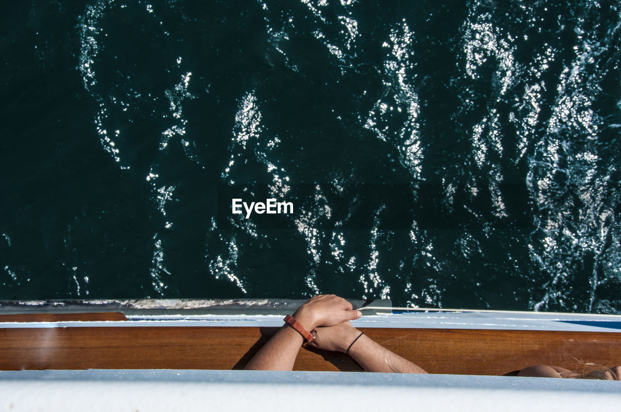 Cropped image of people in boat on sea