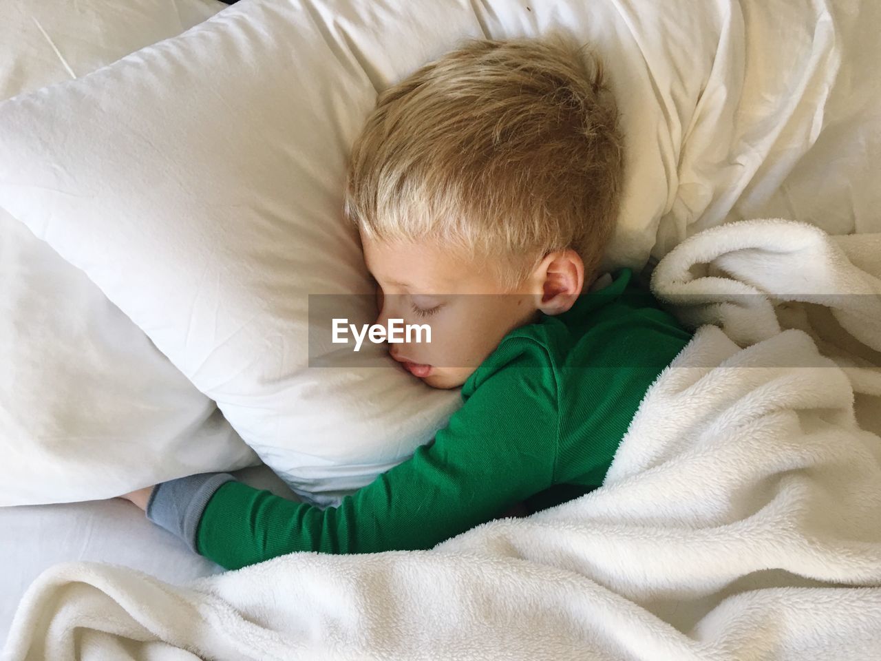 High angle view of boy sleeping on bed
