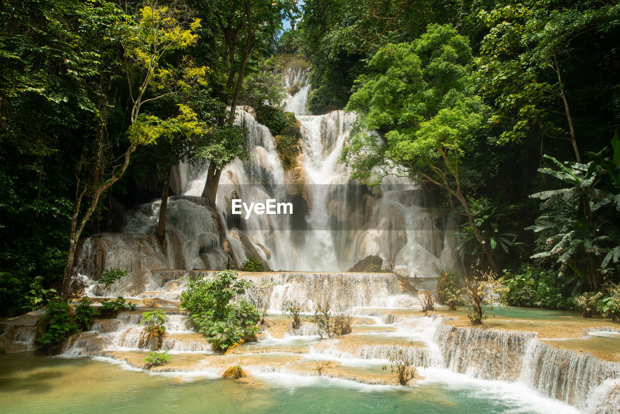 waterfall, water, tree, water feature, plant, beauty in nature, scenics - nature, body of water, nature, environment, motion, flowing water, forest, long exposure, watercourse, land, rock, jungle, travel destinations, travel, rainforest, river, tourism, flowing, outdoors, no people, landscape, water resources, tropical climate, stream, idyllic, non-urban scene, green, blurred motion, splashing, day, growth, social issues, environmental conservation, trip, vacation, rock formation, tranquil scene, sports