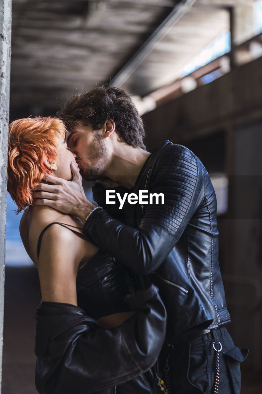 Young couple kissing in underpass