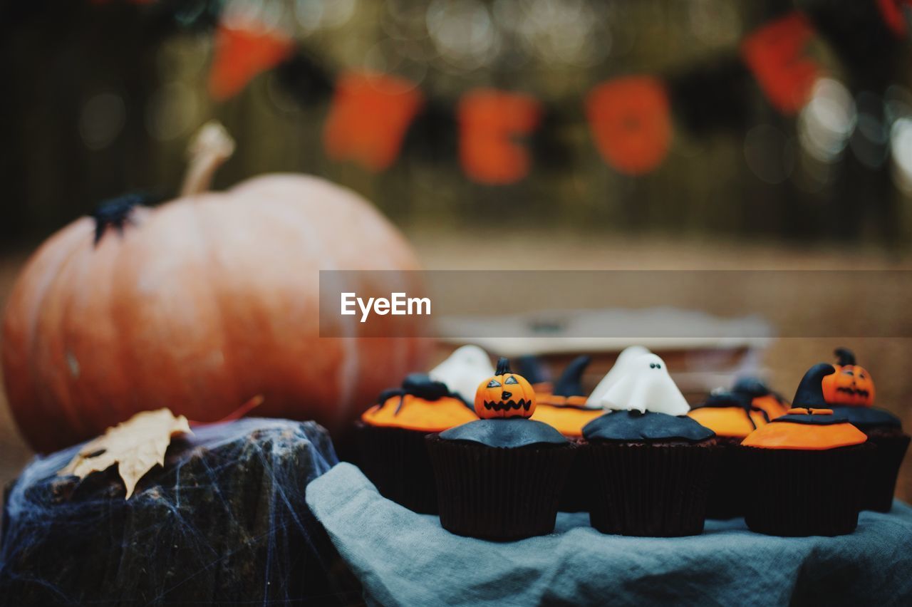 Close-up of cupcakes and pumpkin during halloween celebration