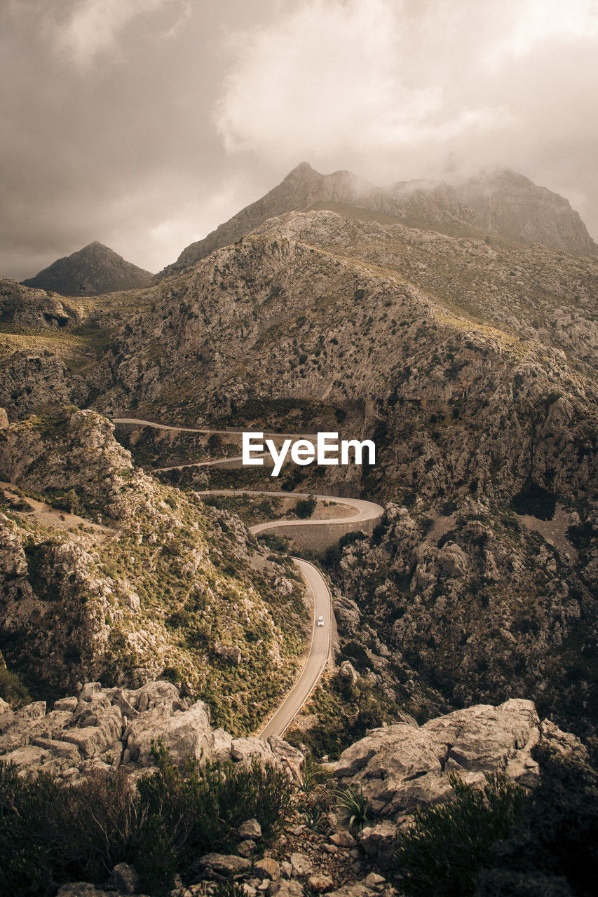 Winding roads amidts rocky mountains against sky