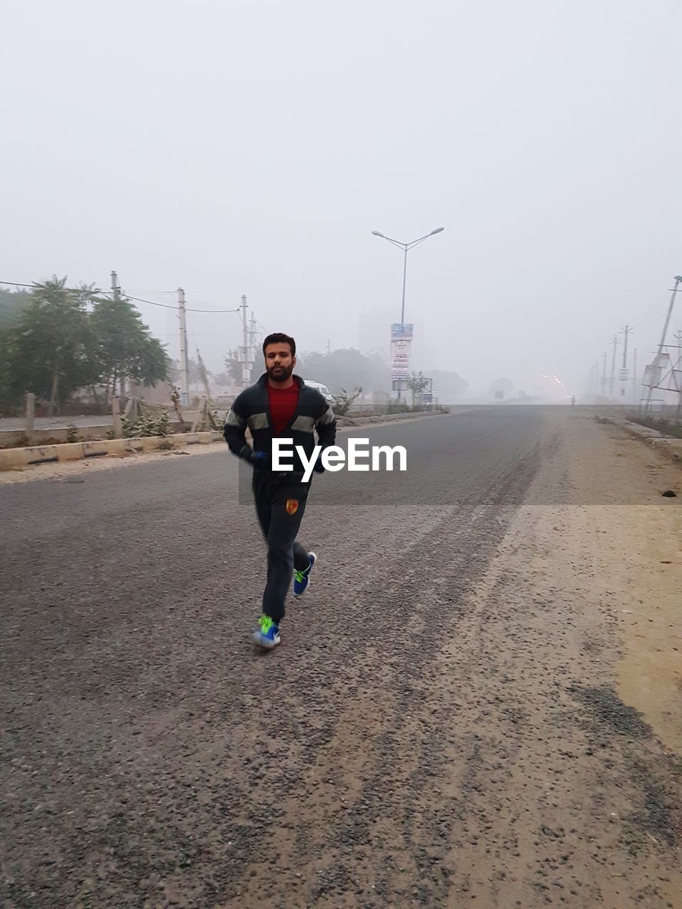 Man running on road during foggy weather