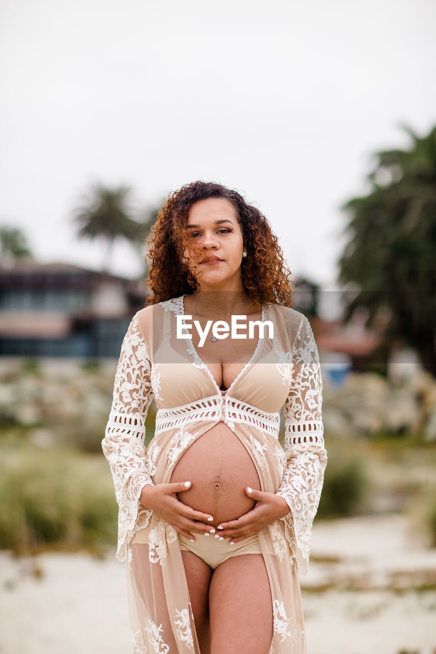 Young pregnant woman posing on beach