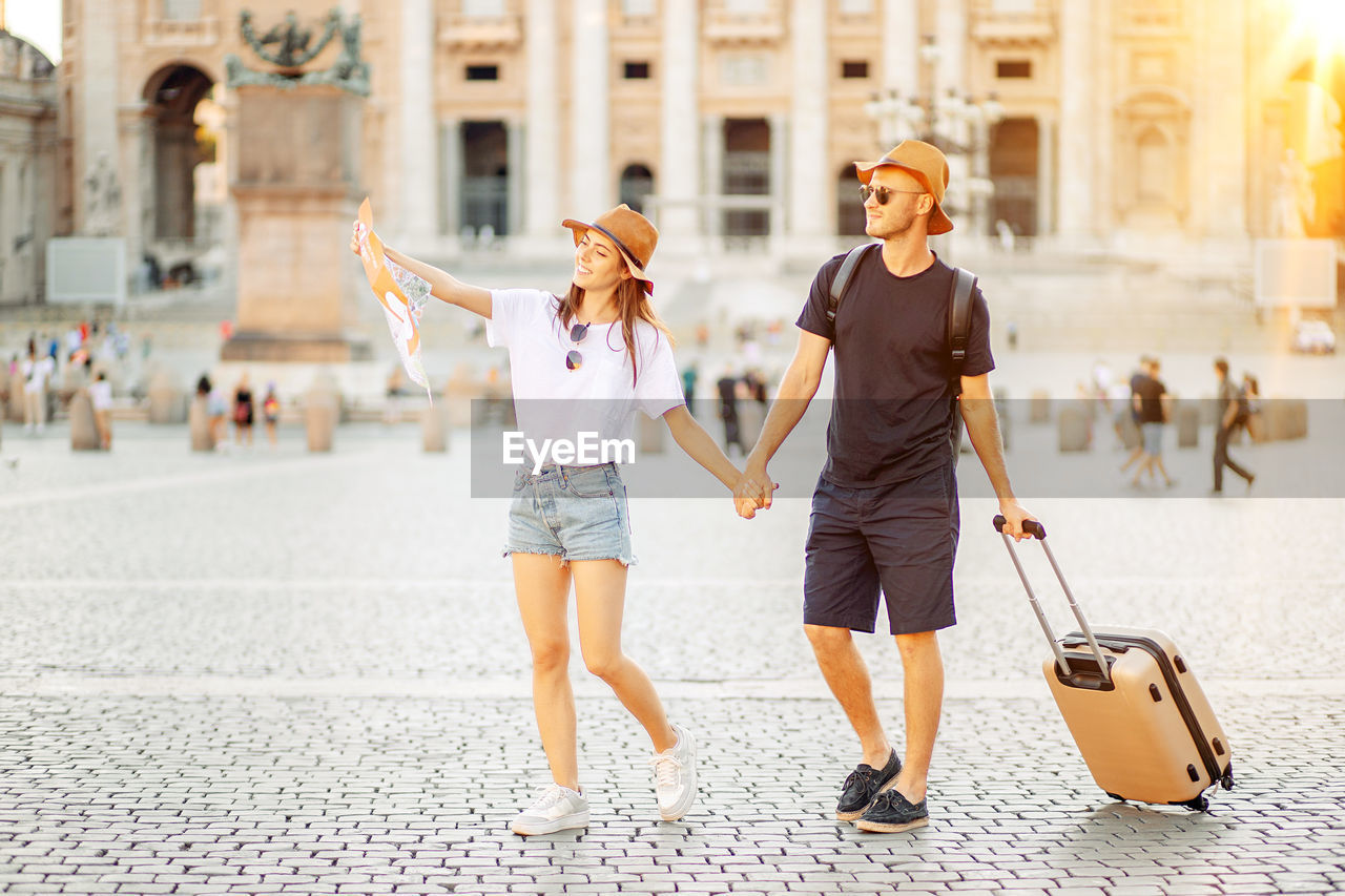 Happy tourists looking at a map and choose a hotel. couple of tourists on vacation in rome, italy. 