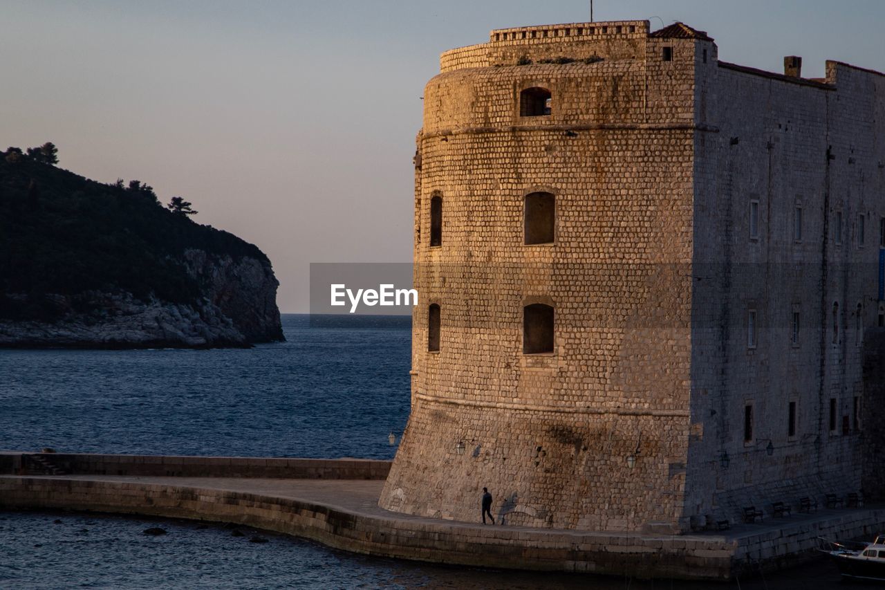 Building by sea against clear sky