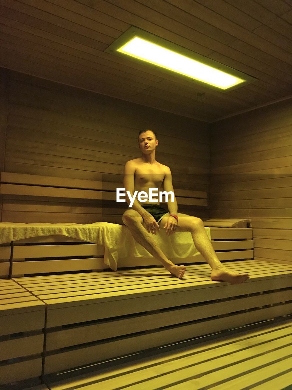 Side view of man relaxing in sauna