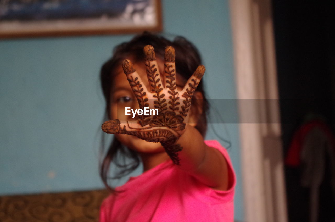 Young girl showing henna painted on hand