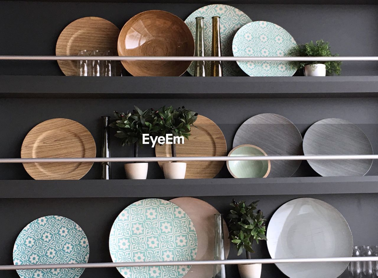 Plates with potted plants arranged on shelf