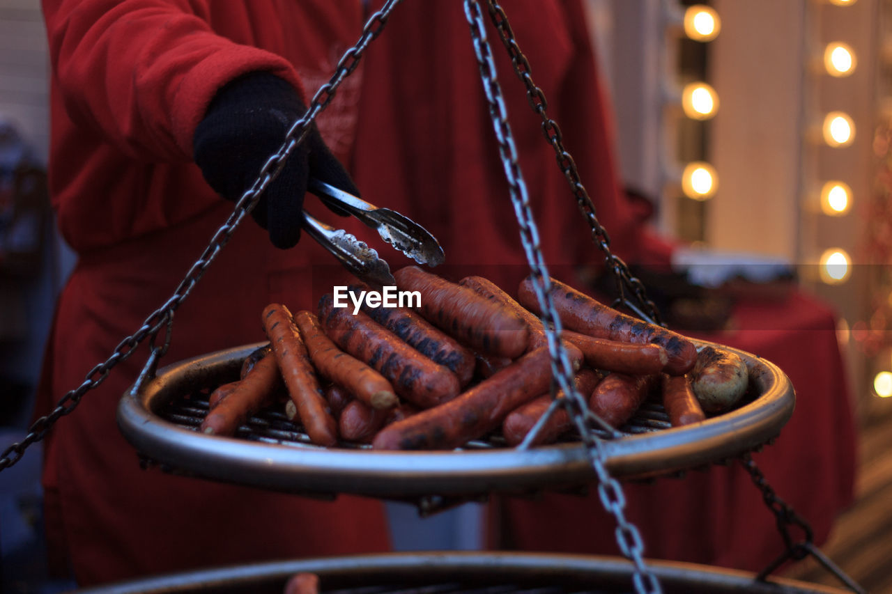 Midsection of person weighing sausages