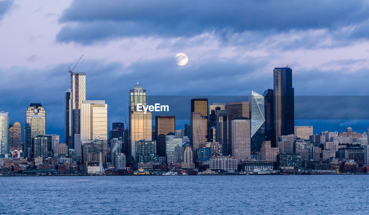 Full moon shines over the seattle skyline.