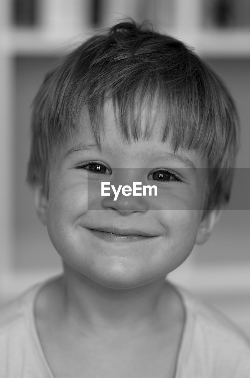 Close-up portrait of cute smiling boy at home