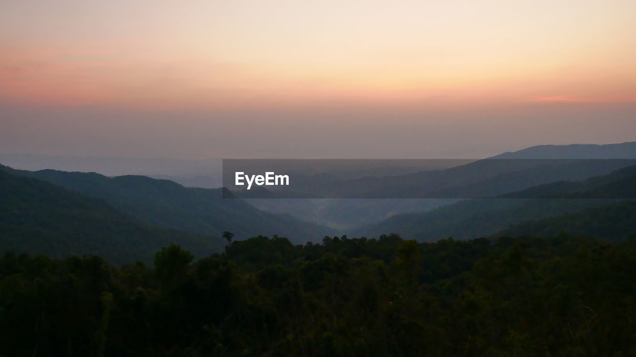 SCENIC VIEW OF MOUNTAINS AGAINST ORANGE SKY