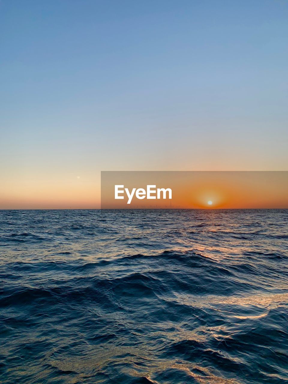 Scenic view of sea against dramatic sky during sunset