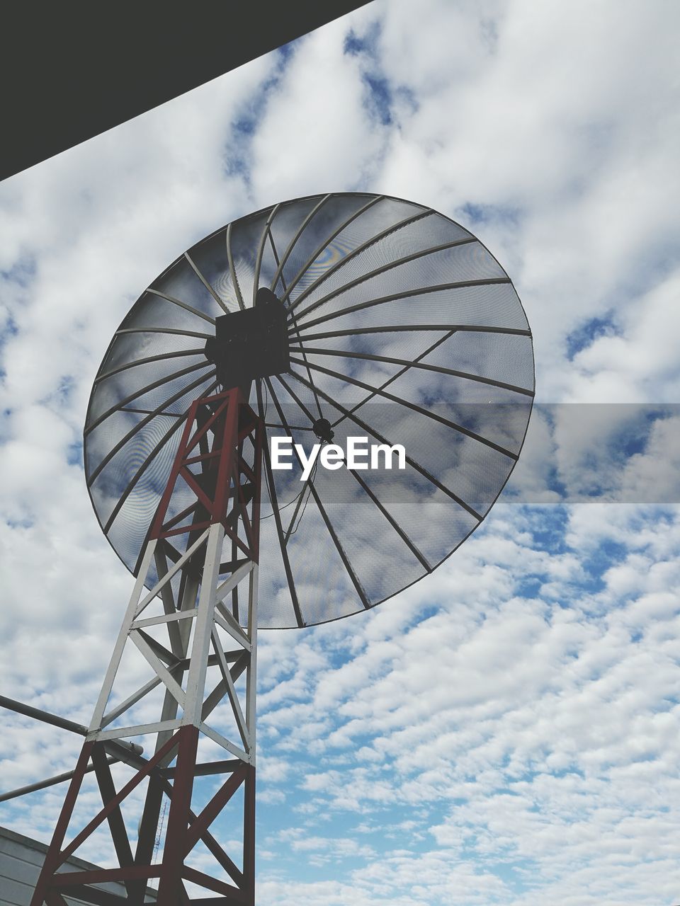 Low angle view of antenna against cloudy sky