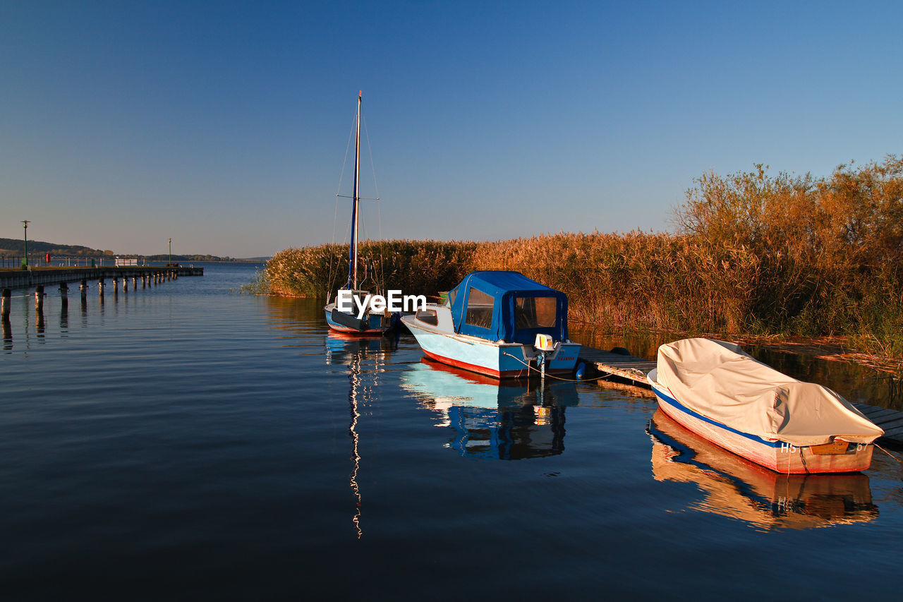 Boats moored in calm blue sea