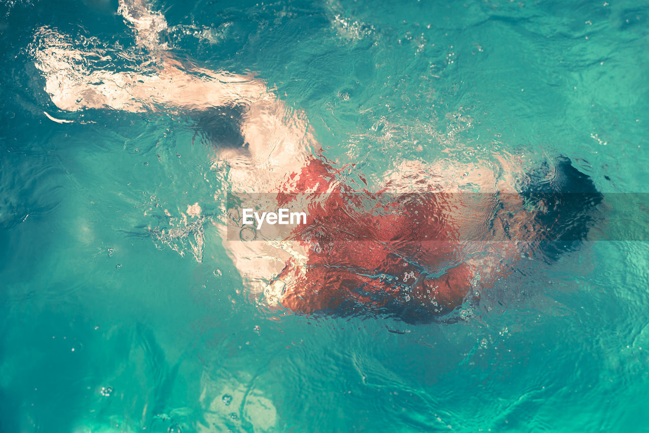 Full length of woman swimming in blue sea