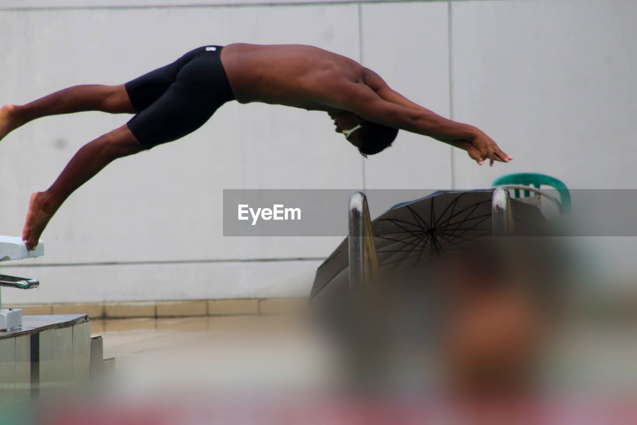 Low section of man exercising on field