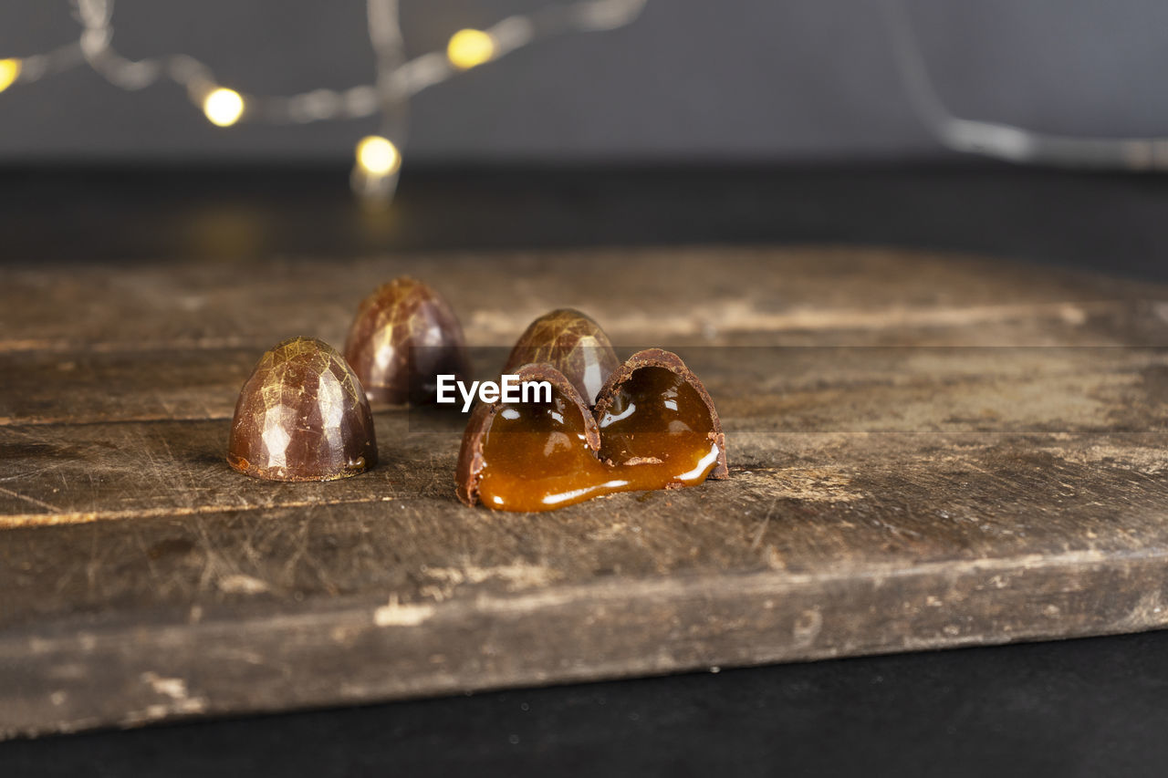 Chocolate candies with liquid filling cut in half. christmas garland background.