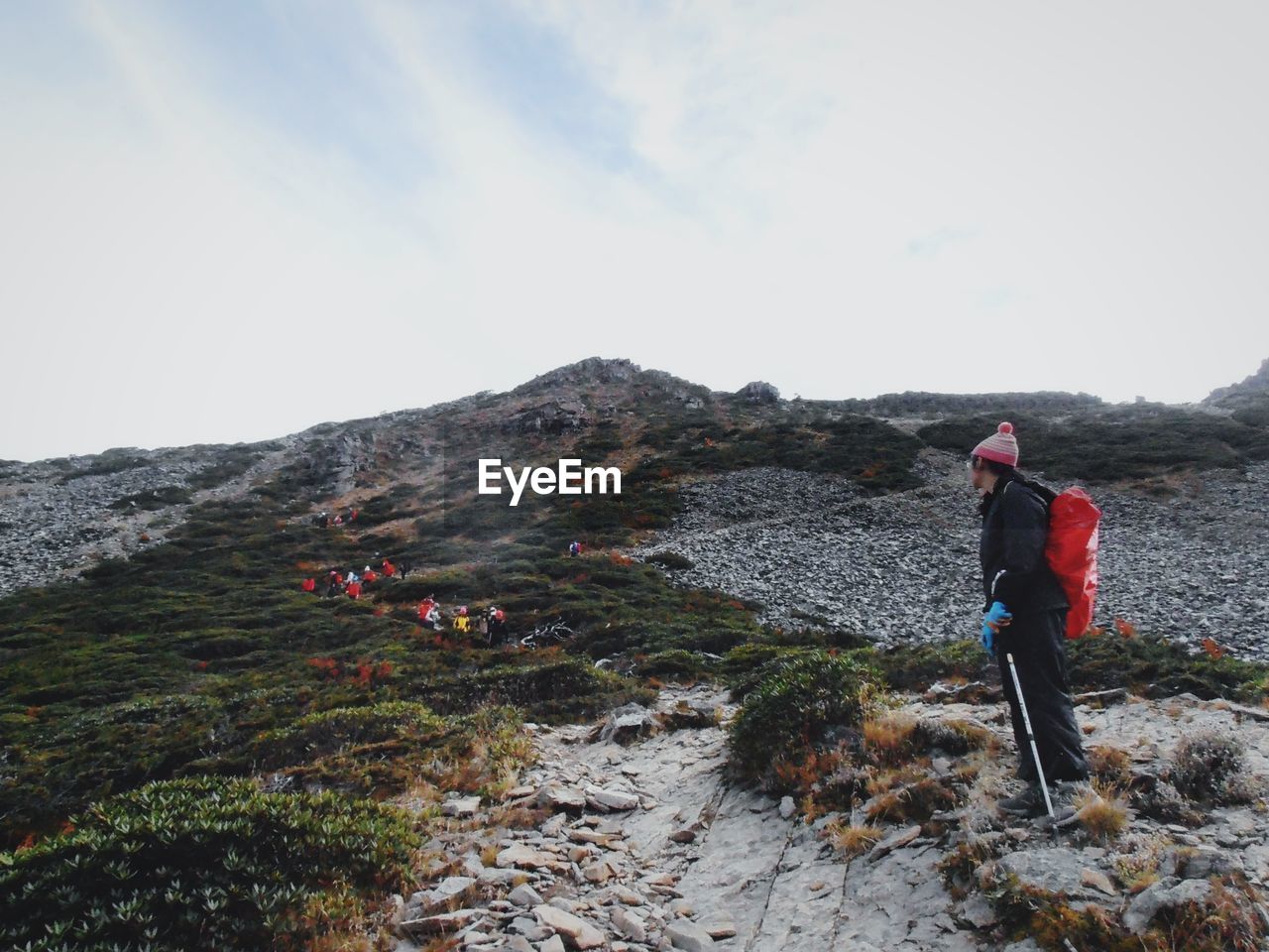 REAR VIEW OF MAN STANDING ON MOUNTAIN