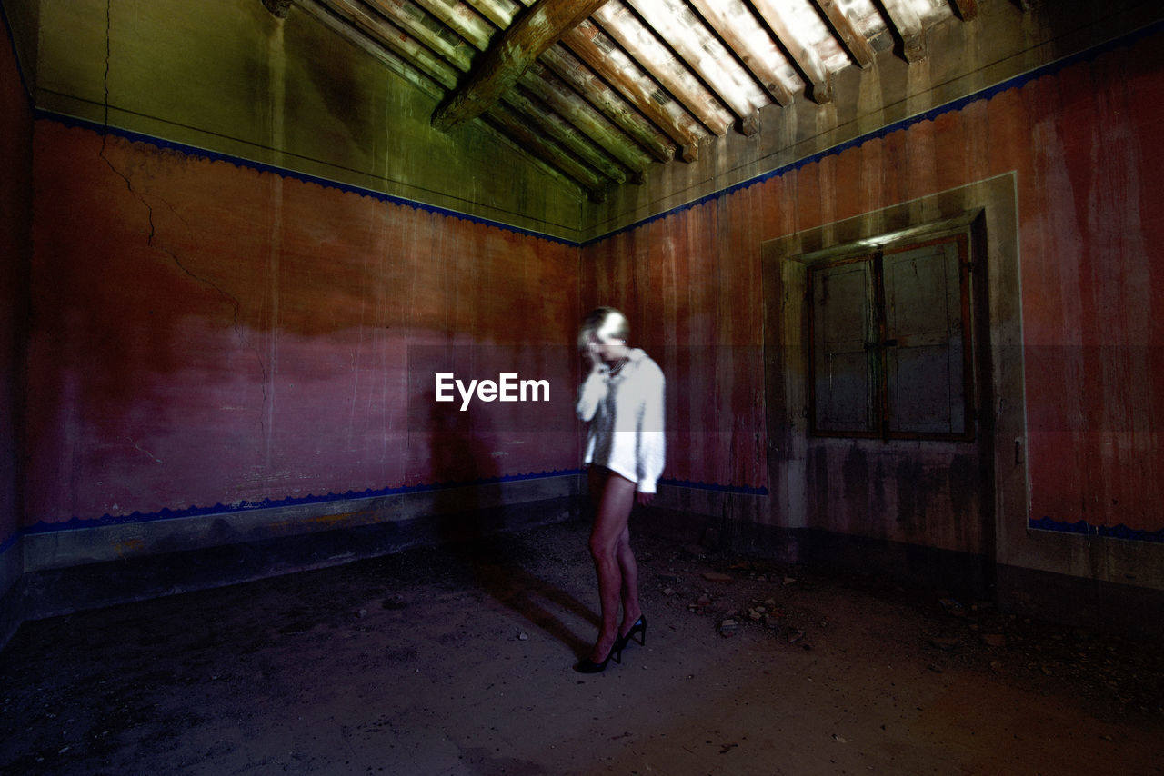 Full length of woman standing in abandoned building