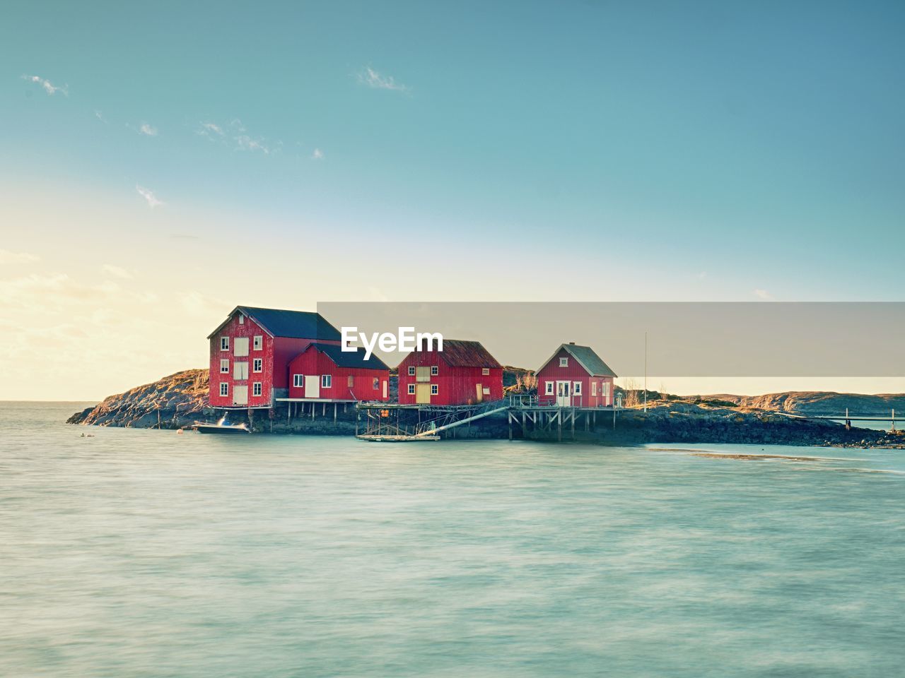 VIEW OF SEA AGAINST BUILDINGS AT SUNSET